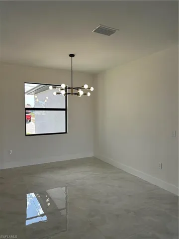 Unfurnished dining area featuring hanging lights and baseboards