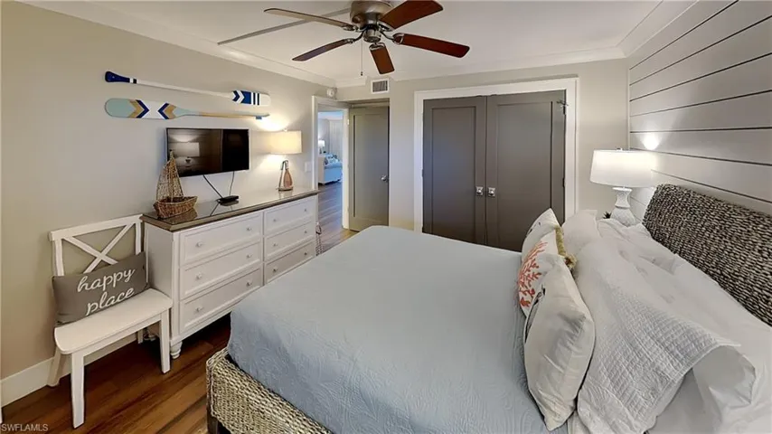 Interior room featuring wood-finish flooring, a ceiling fan, and crown molding