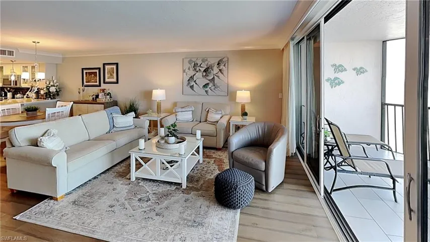 Open concept living area with light-toned walls and wood-finish flooring