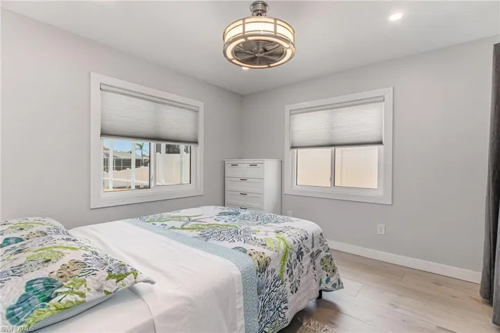 Bedroom featuring baseboards, wood finished floors, and recessed lighting & ceiling fan