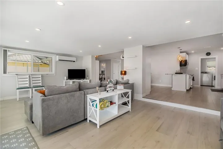 Living room with an extra mini split AC wall unit,  and recessed lighting