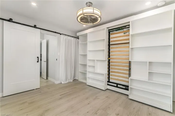 Bedroom showing Murphy Bed in upright position with sliding shelf unit