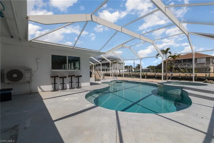 View  patio area, pool with connected hot tub, screened in