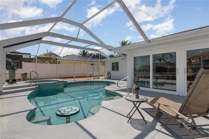 View of pool with a patio area, a pool with connected hot tub,
