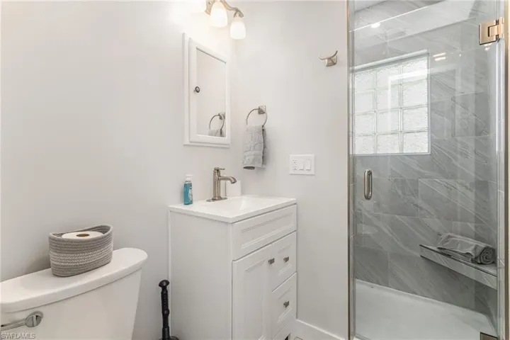 Full bathroom with toilet, vanity, and a shower stall