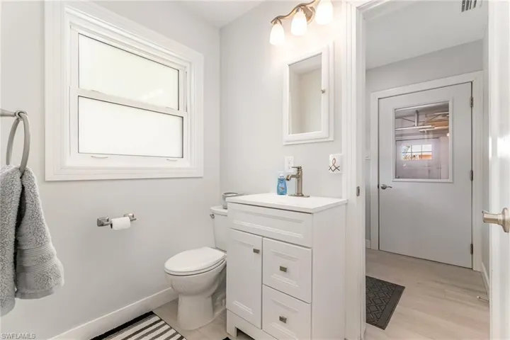 Half bathroom featuring , wood grain tile floors, vanity, and baseboards