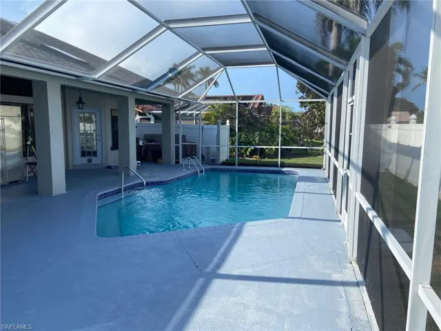 View of pool featuring patio surround, a sunroom, and a lanai