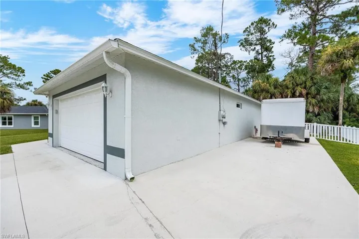 View of side of home with a garage and a yard