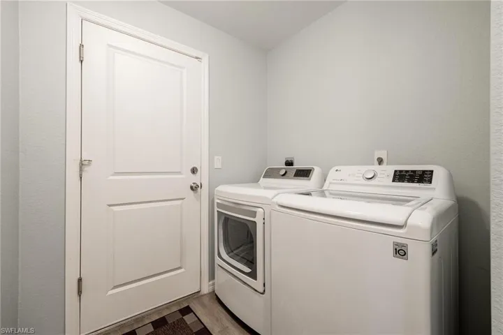 Laundry room with independent washer and dryer and light wood-type flooring