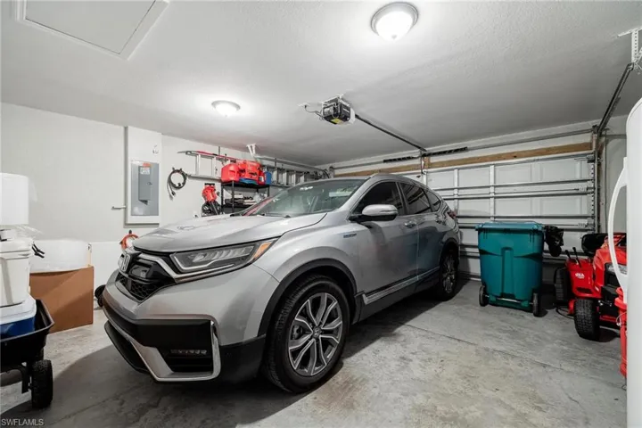 Garage featuring a garage door opener and electric panel