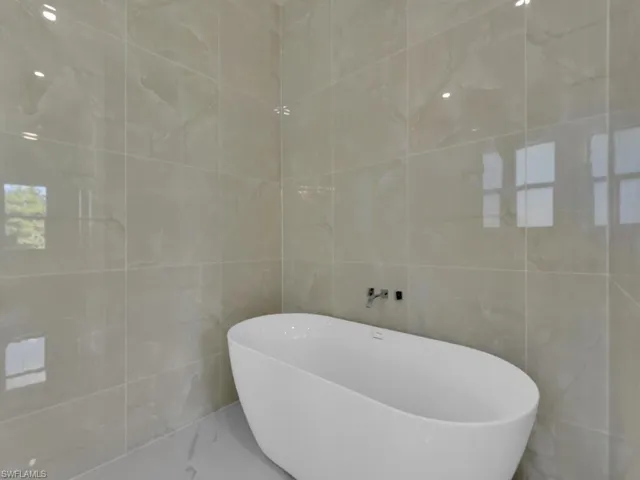 Bathroom featuring tile walls and a washtub