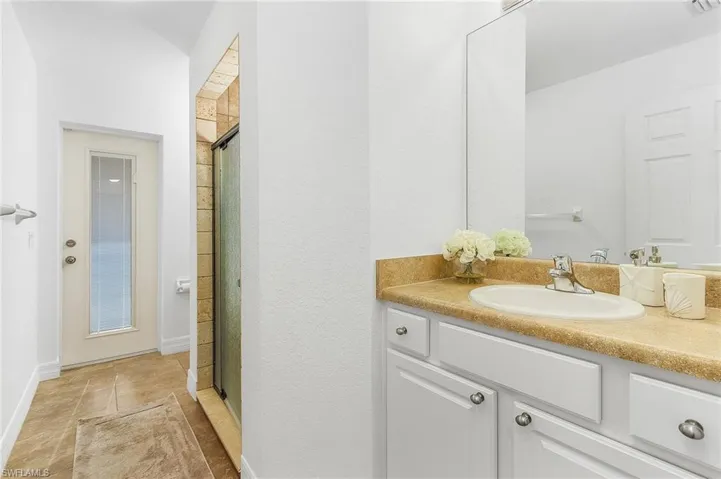 Bathroom featuring vanity, tile patterned floors, and a shower with door