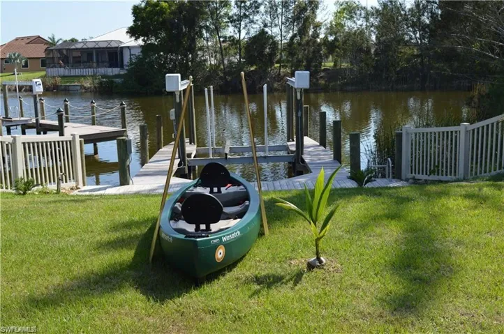 View of dock with a water view and a yard