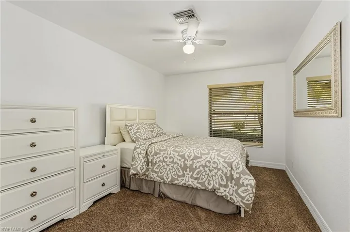 Bedroom with dark carpet and ceiling fan