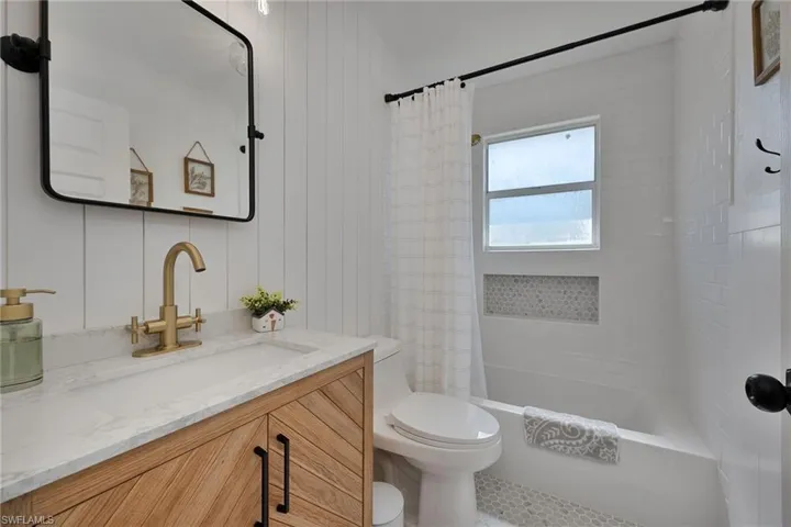 Full bathroom featuring shower / bath combo with shower curtain and vanity
