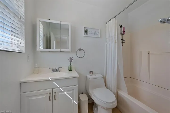 Full bath featuring vanity and shower / tub combo with curtain
