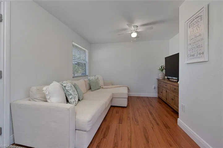Living area with wood finished floors and a ceiling fan