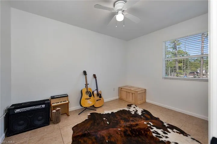 Misc room featuring light tile patterned flooring and ceiling fan