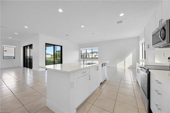 Kitchen featuring kitchen island with quartz countertops, modern cabinetry, and stainless steel appliances.