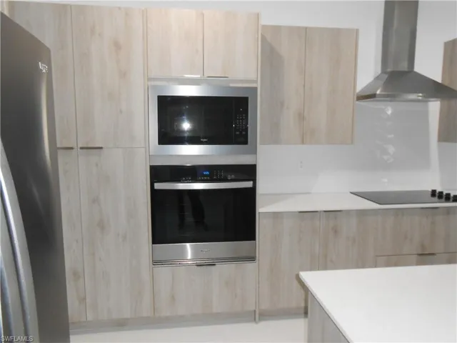 Kitchen with light wood finish cabinets, modern cabinets, and stainless steel appliances