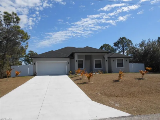 View of front of property with stucco siding, driveway, a garage, roof with shingles, and a gate