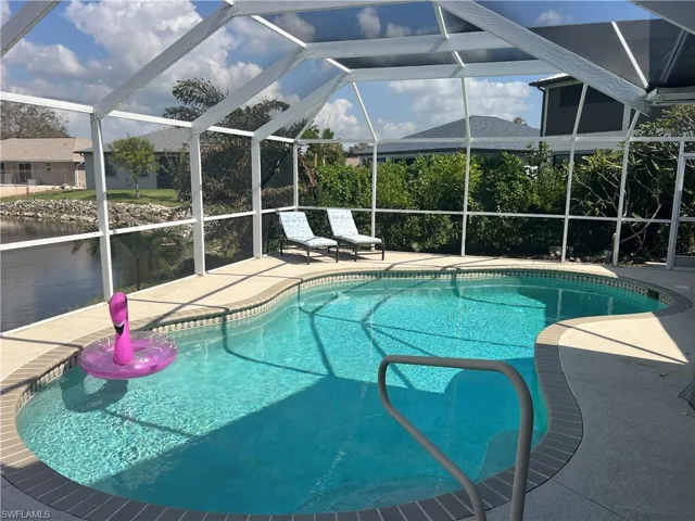 View of swimming pool featuring a patio area, a lanai, and a water view