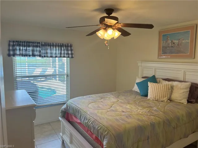 Tiled bedroom featuring ceiling fan