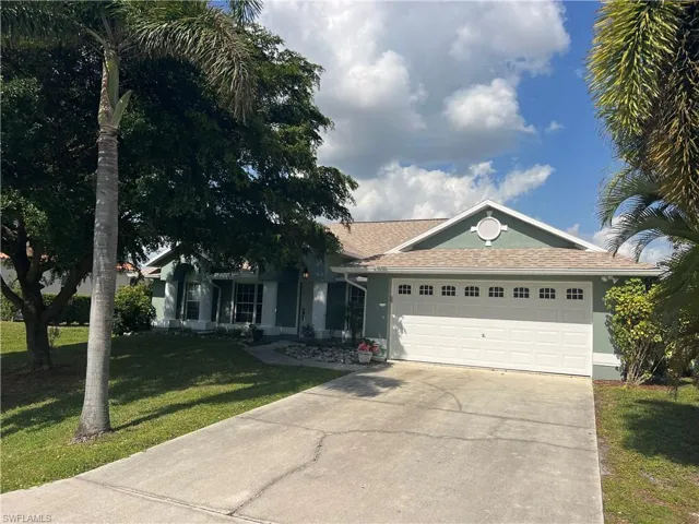 Ranch-style house with a front lawn and a garage