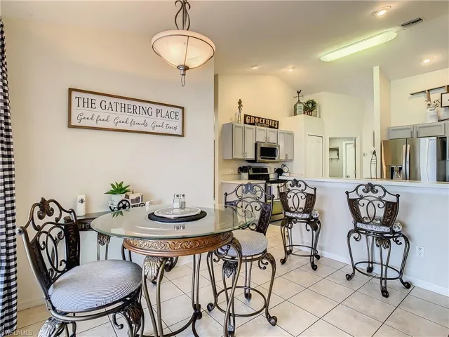Tiled dining space with lofted ceiling