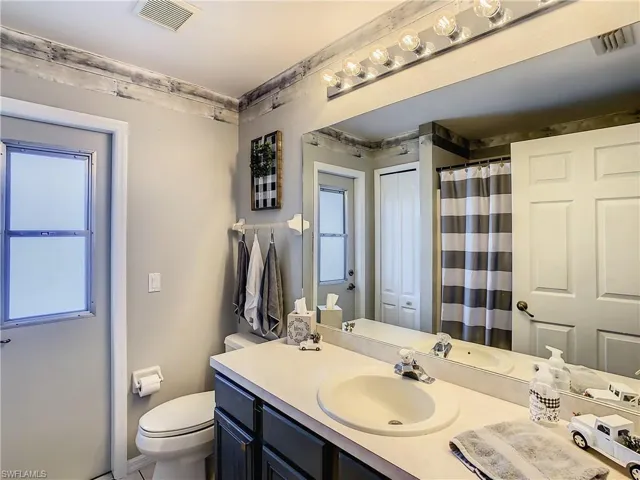 Bathroom featuring vanity, toilet, and plenty of natural light