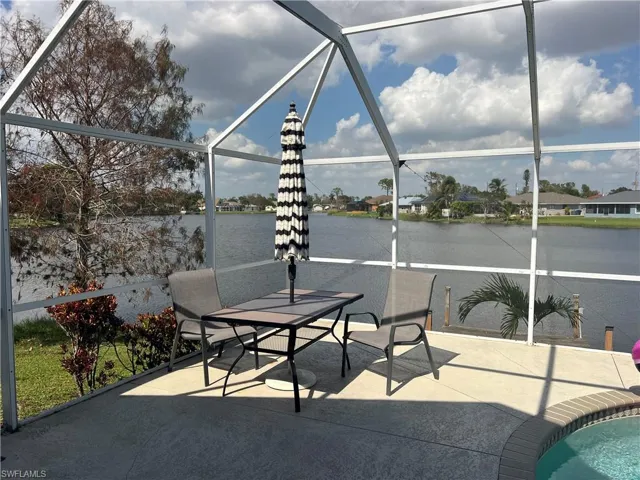 View of patio with a water view and glass enclosure