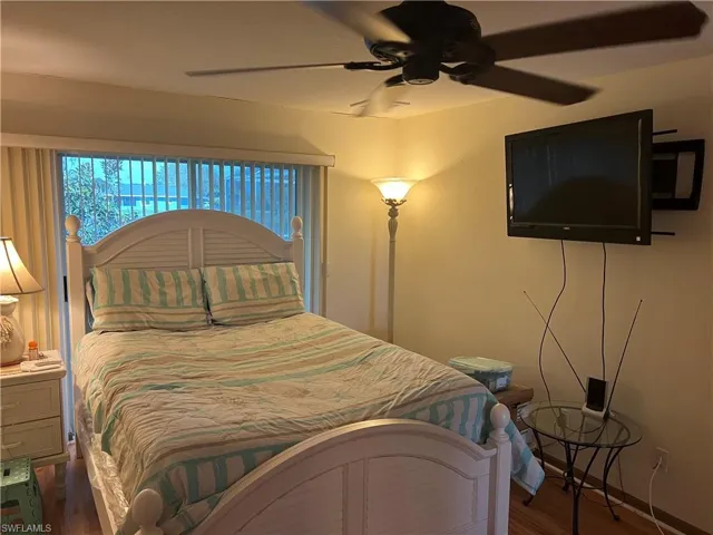 Bedroom with dark wood-type flooring and ceiling fan