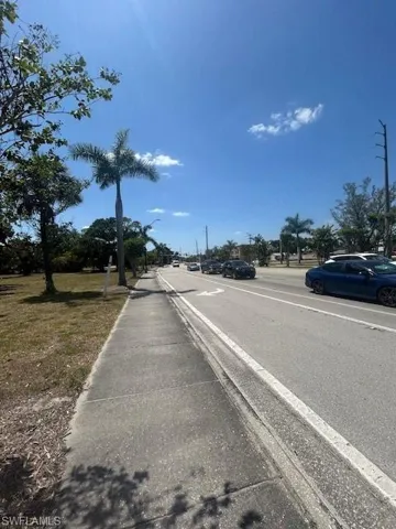 View of street featuring curbs, sidewalks, and street lighting