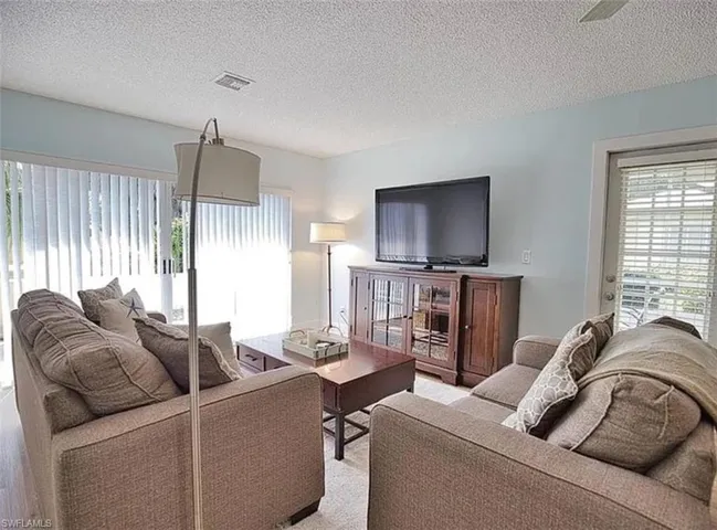 Living area featuring a textured ceiling and ceiling fan