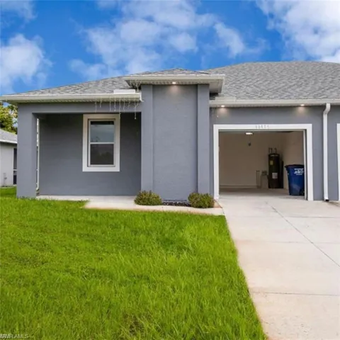 View of front of property with an attached garage, stucco siding, concrete driveway, roof with shingles, and a front yard