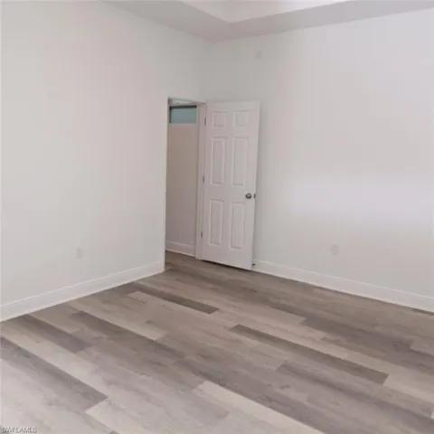 Unfurnished room with light wood-style floors and baseboards