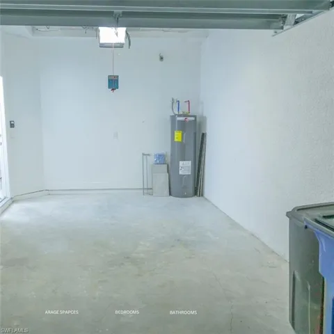 Garage featuring water heater, a textured wall, and a garage door opener