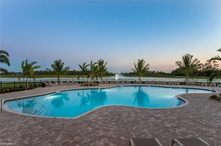 Pool at dusk with a patio and a community pool