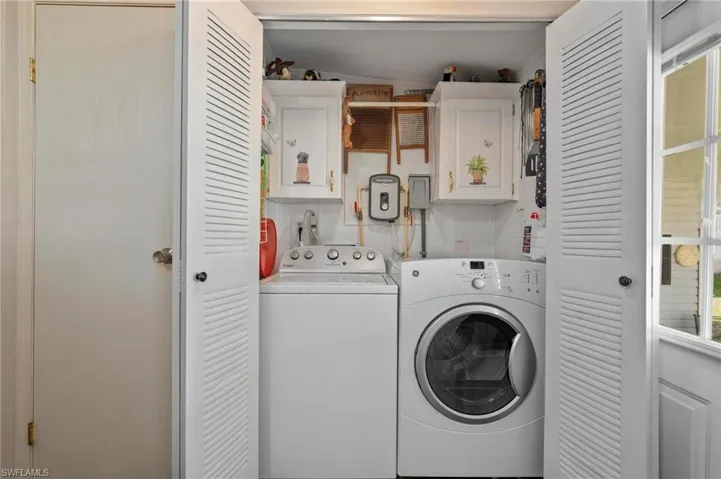Washroom featuring independent washer and dryer and cabinet space