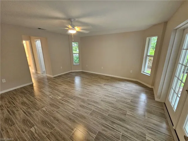 Spare room featuring ceiling fan, hardwood / wood-style flooring, and a textured ceiling