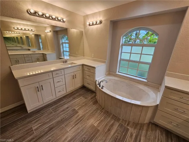 Bathroom with double sink vanity and a tub to relax in