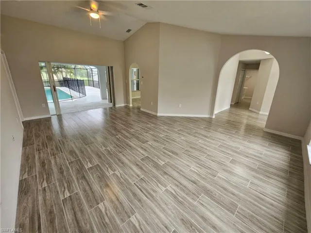 Spare room featuring light hardwood / wood-style flooring, ceiling fan, and high vaulted ceiling