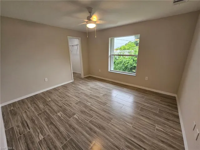 Empty room with wood-type flooring and ceiling fan