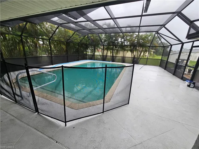 View of swimming pool with a patio area and a lanai
