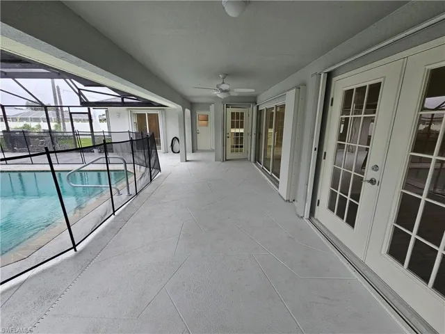 View of pool with a lanai, a patio, and ceiling fan