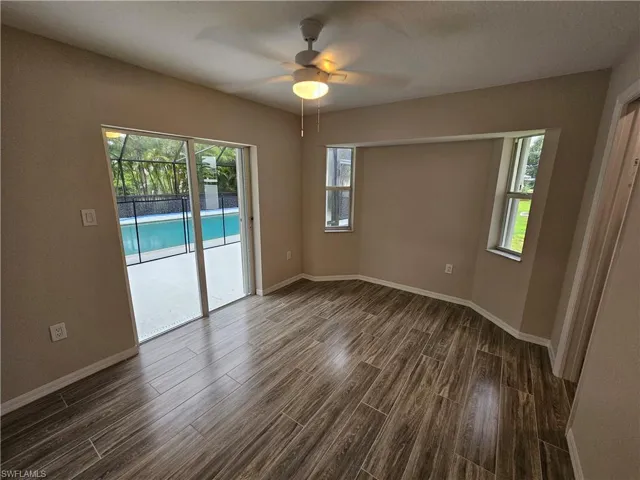 Unfurnished room featuring ceiling fan and dark hardwood / wood-style flooring