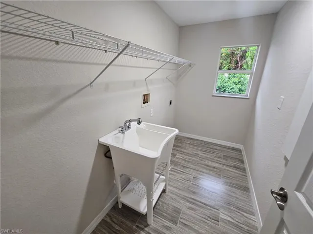 Laundry area with tile patterned floors, hookup for an electric dryer, and washer hookup