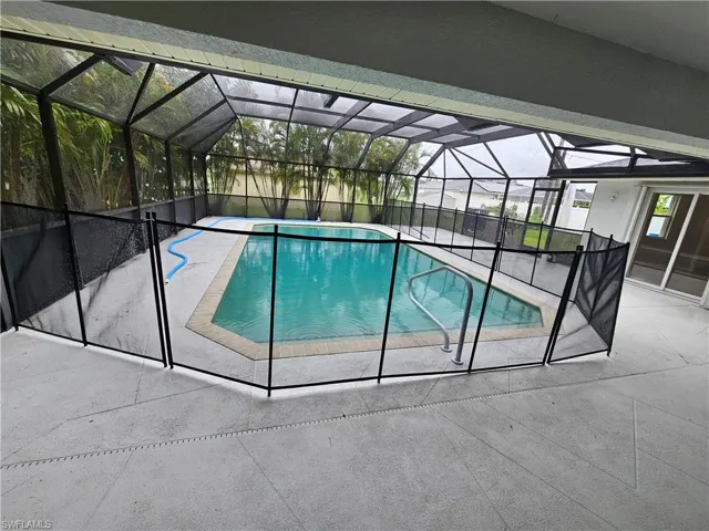 View of swimming pool featuring a lanai and a patio area
