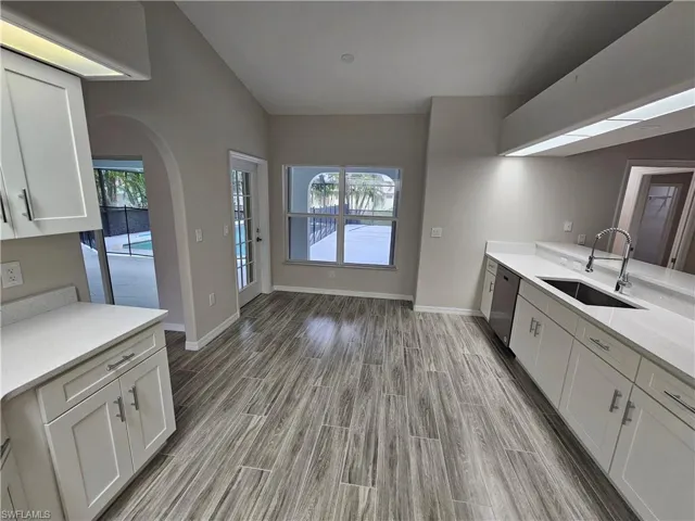 Bathroom with wood-type flooring, sink, and vaulted ceiling