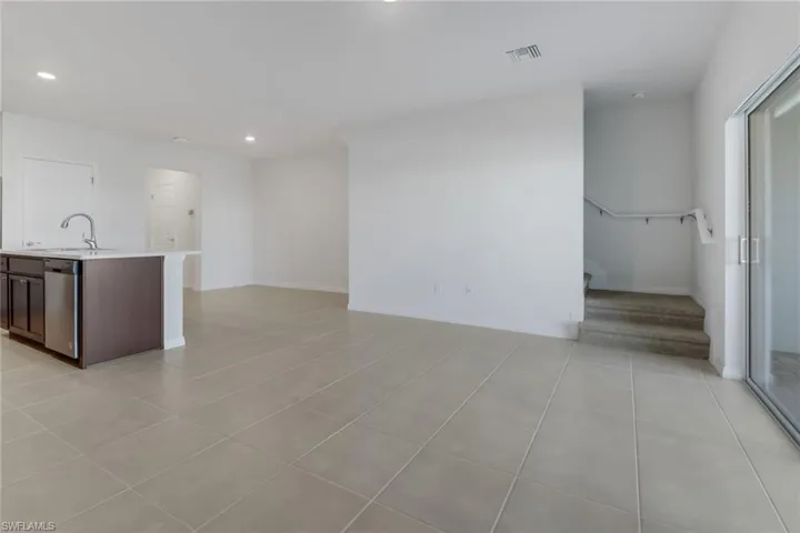 Family room and kitchen featuring sink and light tile patterned floors